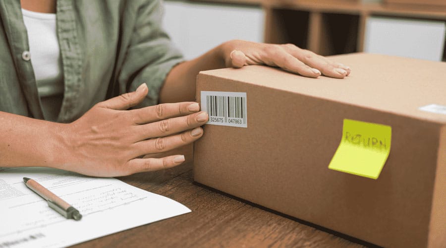 Pessoa a embalar uma encomenda para devolução ao abrigo do direito de livre resolução para compras online.